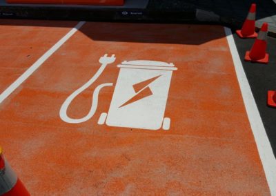 Private orange non-skid EV charging space using electricity made from waste